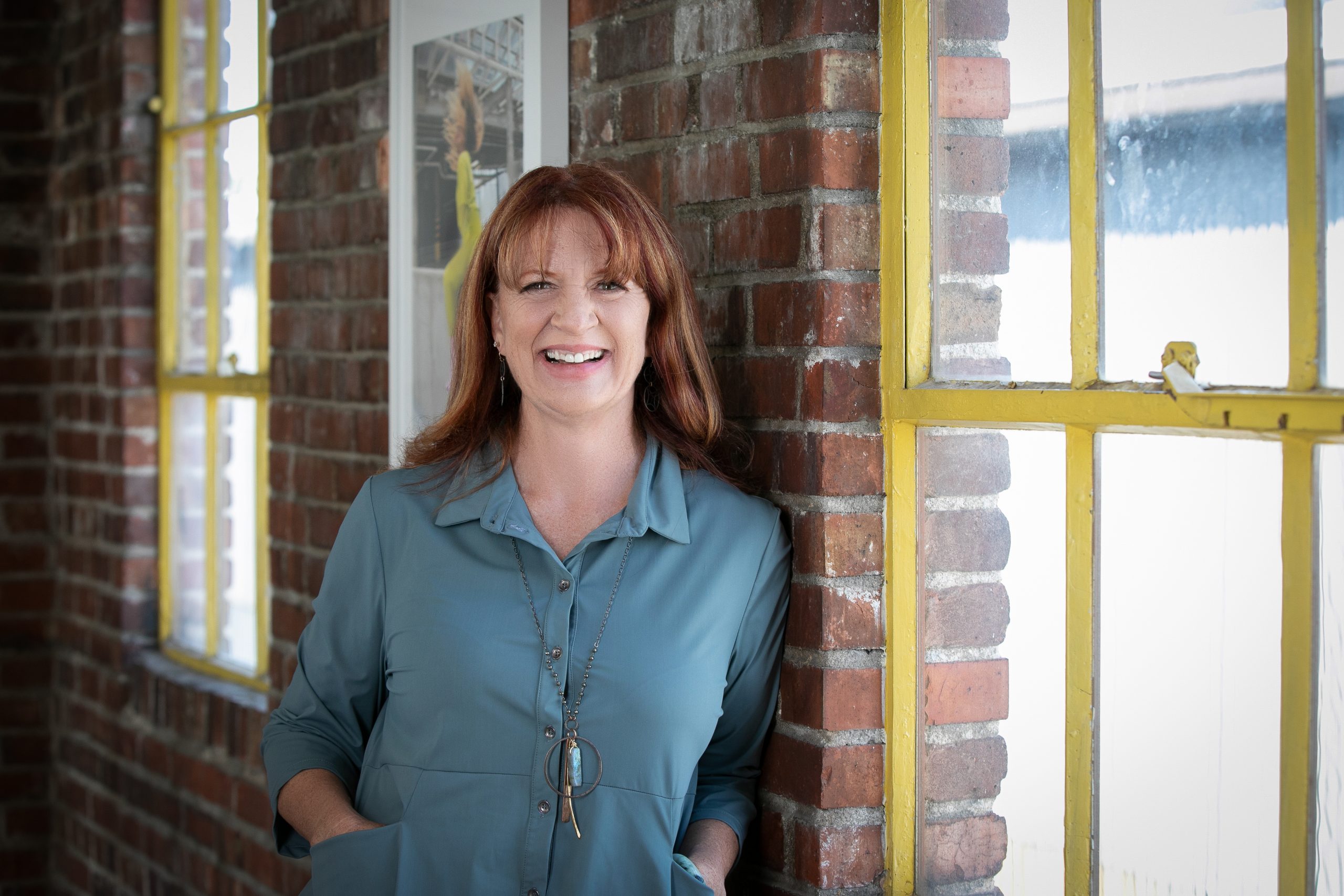 dr. ross standing in front of a brick wall and windows wit yellow trim