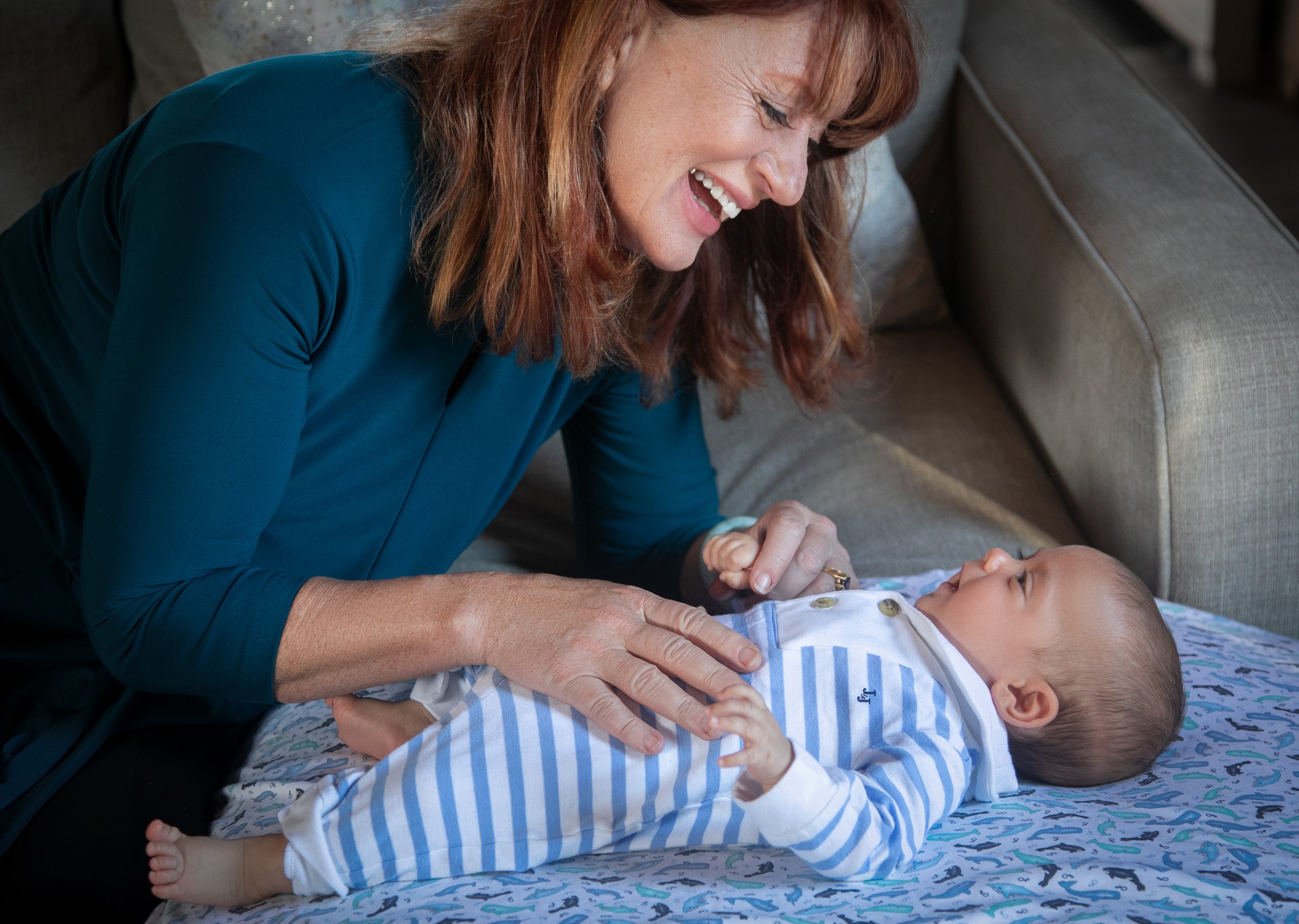 Dr Ross looking down at a baby dressed in blue